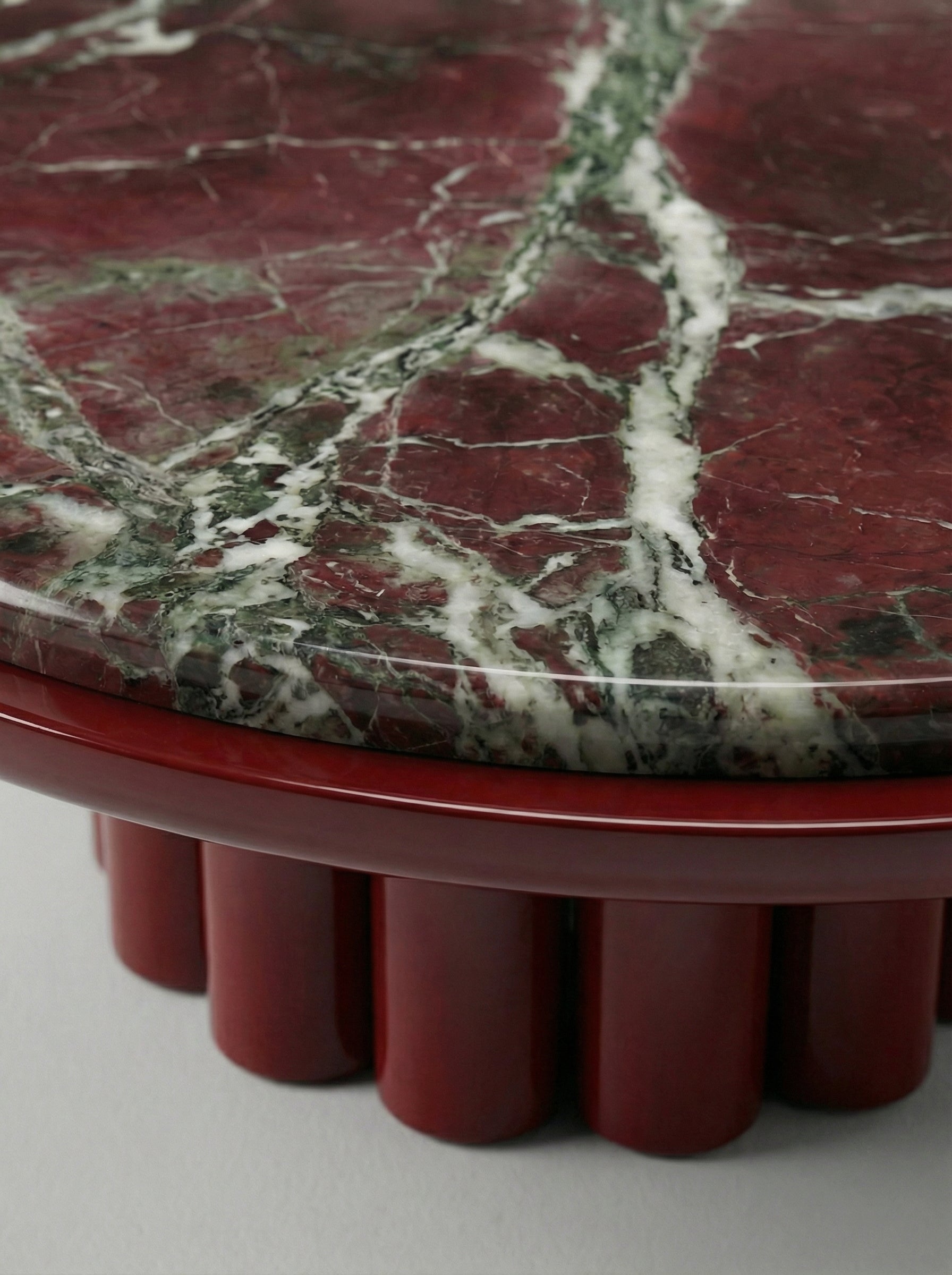 Back view of Edoni piece showcasing bordeaux lacquer finish and Rosso Levanto marble combination