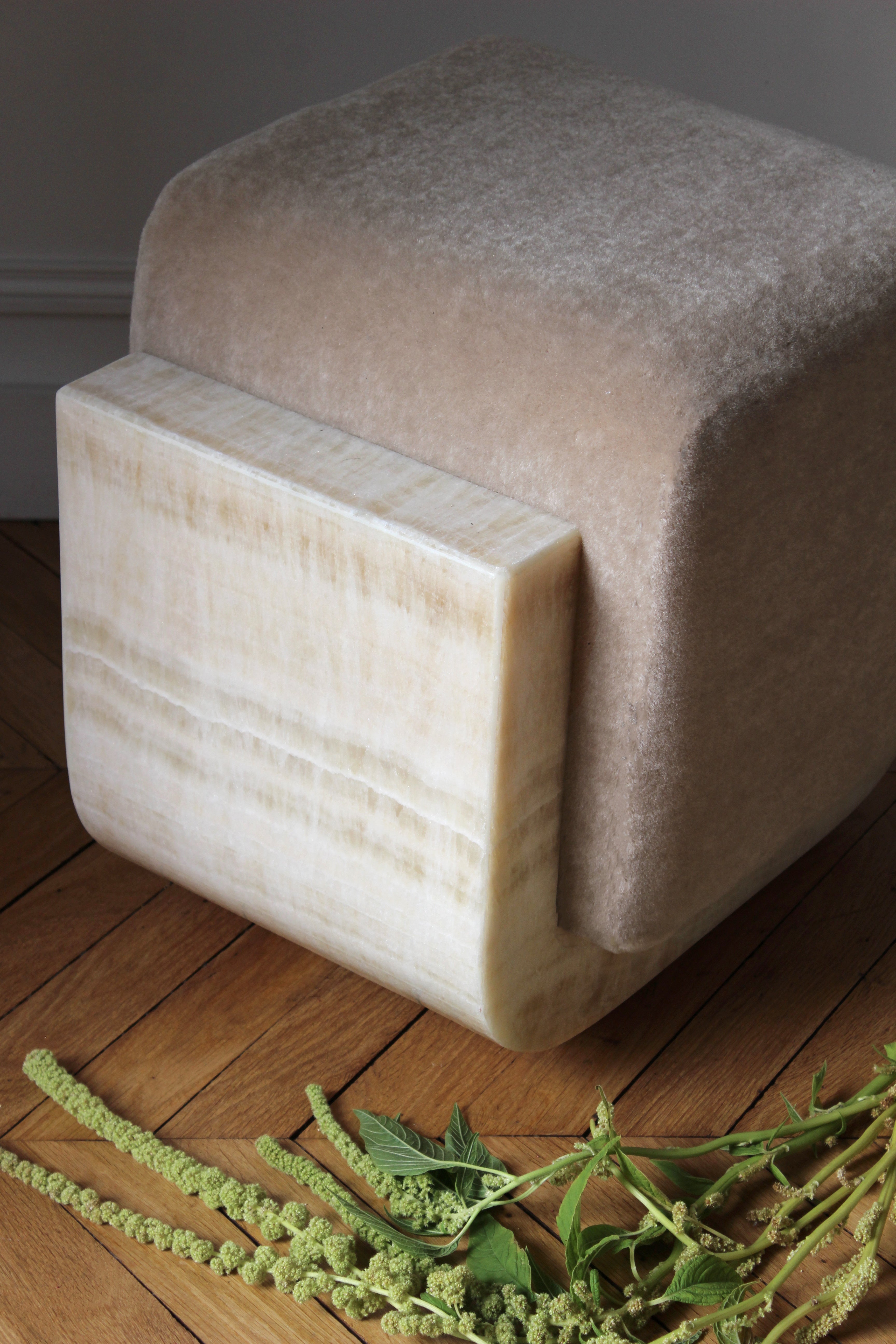 Alternative perspective of ivory onyx mohair Oggy stool highlighting marble veining and mohair upholstery