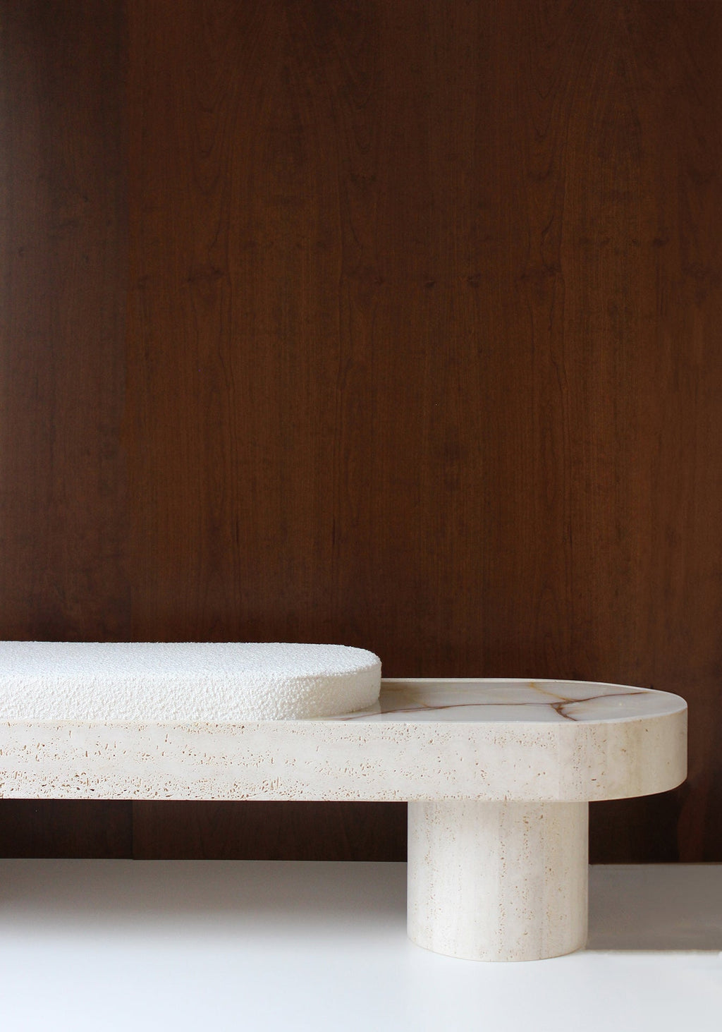 Luxury Noto travertine bench with bouclette cushioning - detailed view of natural stone base