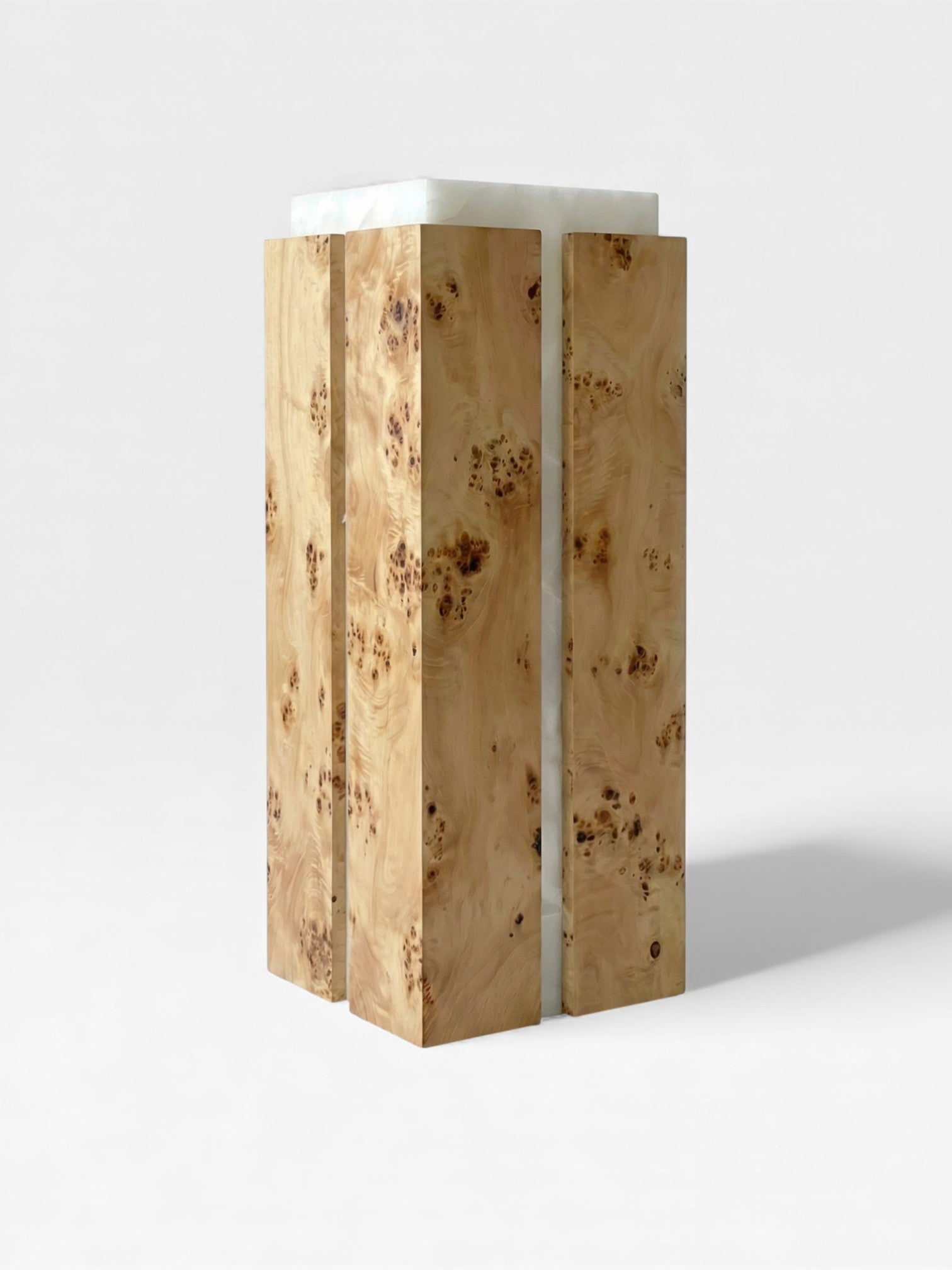 Left angle view of Como plinth highlighting burl wood's natural patterns with white onyx marble top