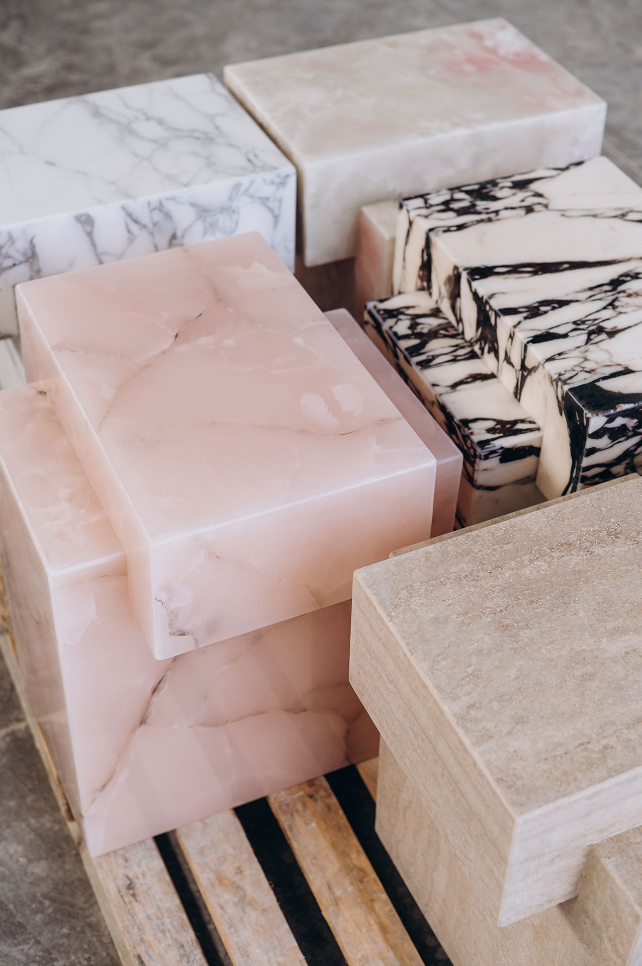 Pink onyx coffee table styled in contemporary living room with green accent wall and modern decor