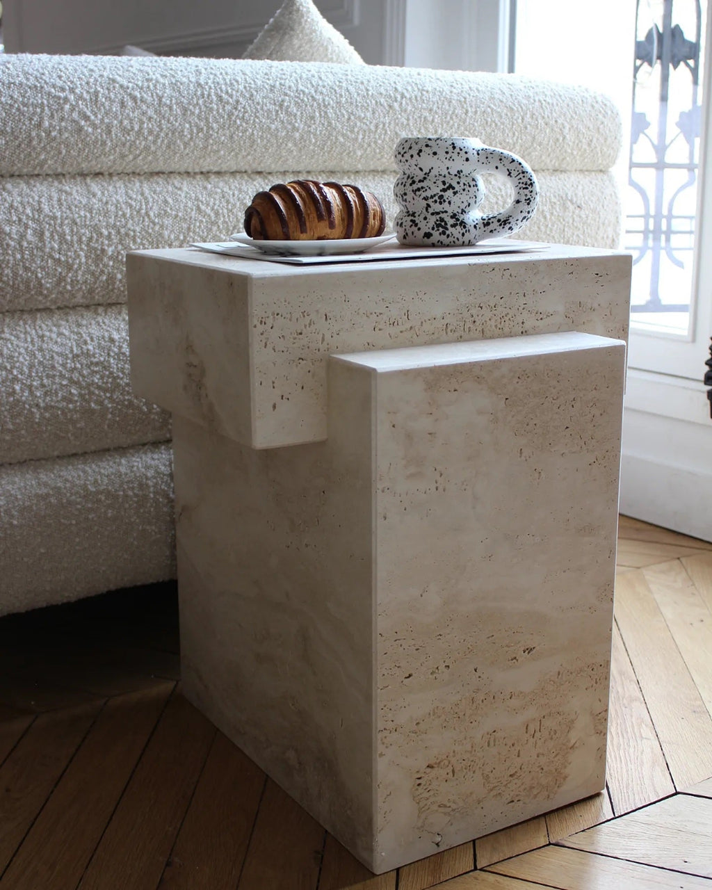 Travertine marble coffee table in contemporary interior setting with modern furniture and lighting