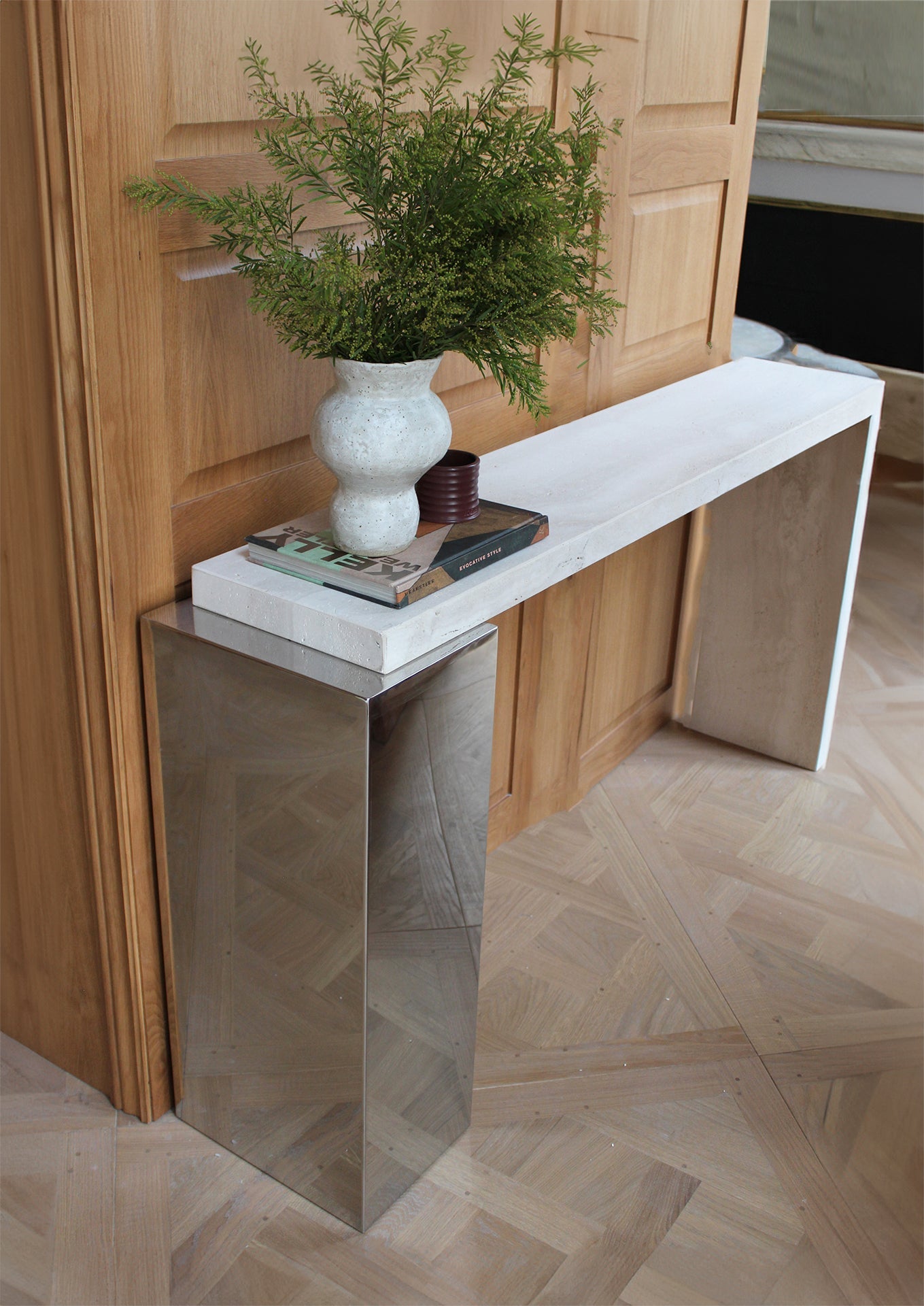 Alternative angle of travertine Jill console displaying marble surface patterns and modern steel support