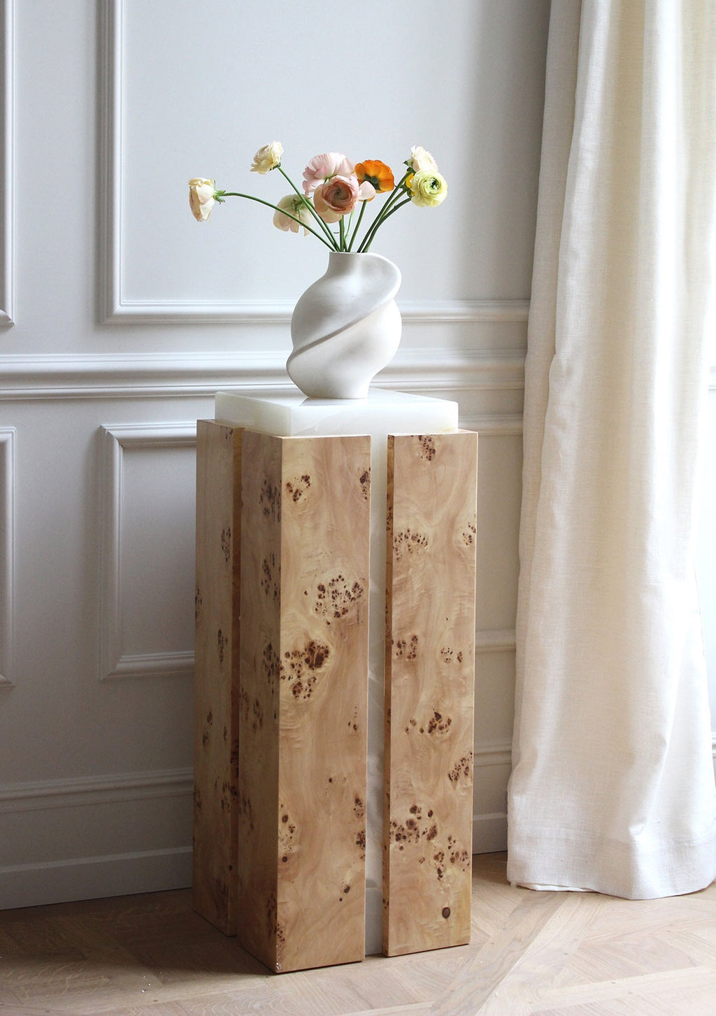Profile view of Como plinth showcasing burl wood grain and white onyx contrast - premium Italian furniture