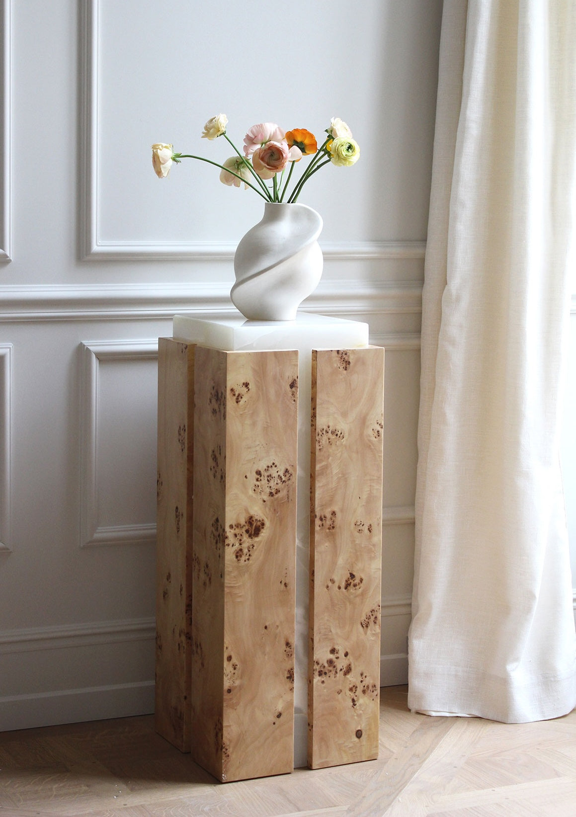 Profile view of Como plinth showcasing burl wood grain and white onyx contrast - premium Italian furniture