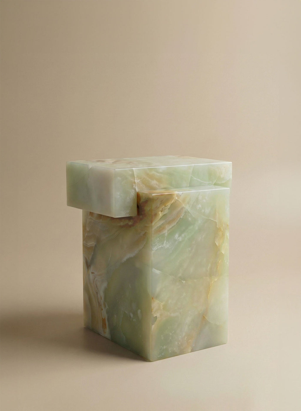 Three-quarter angle view of green onyx marble table showing sculptural form and elegant proportions