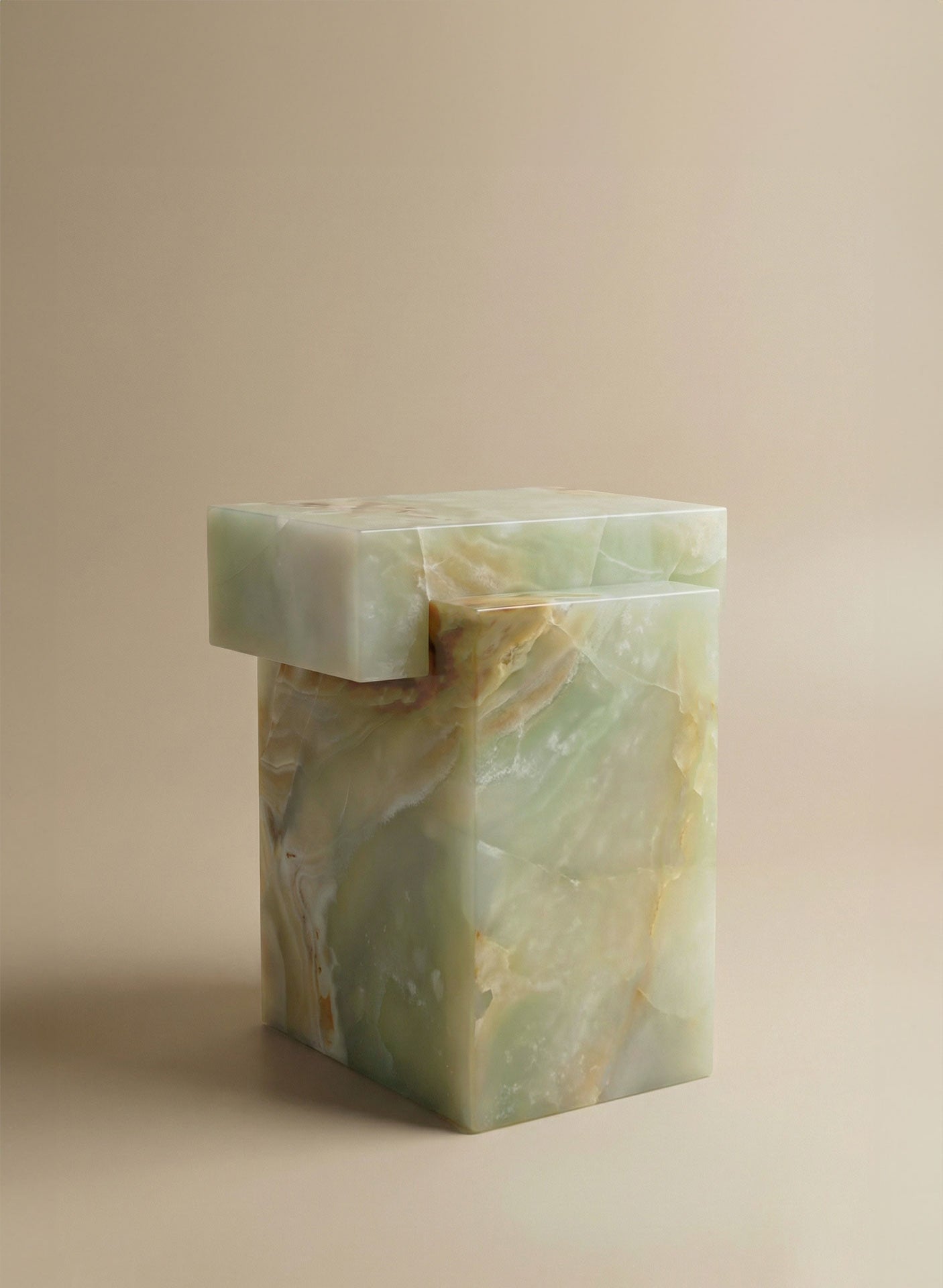 Three-quarter angle view of green onyx marble table showing sculptural form and elegant proportions