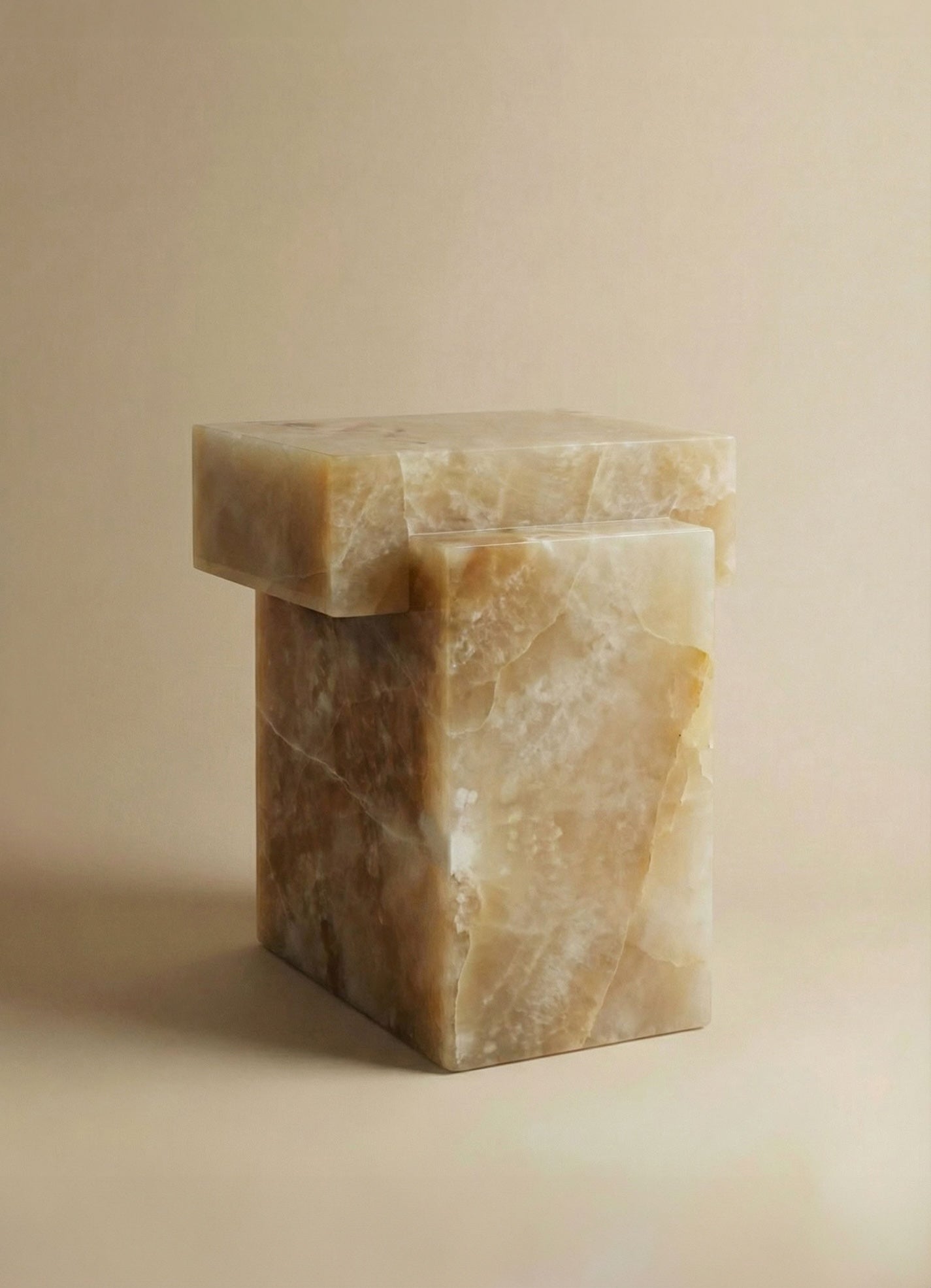 Three-quarter view of honey onyx table showcasing natural amber veining and sculptural marble form