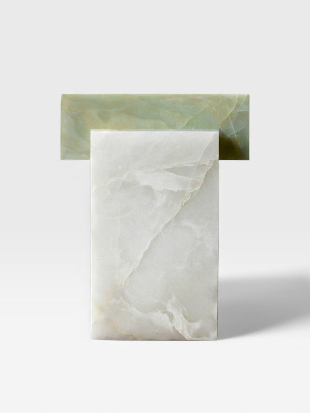 Profile view of white and green onyx table showing natural stone contrast and sculptural form details