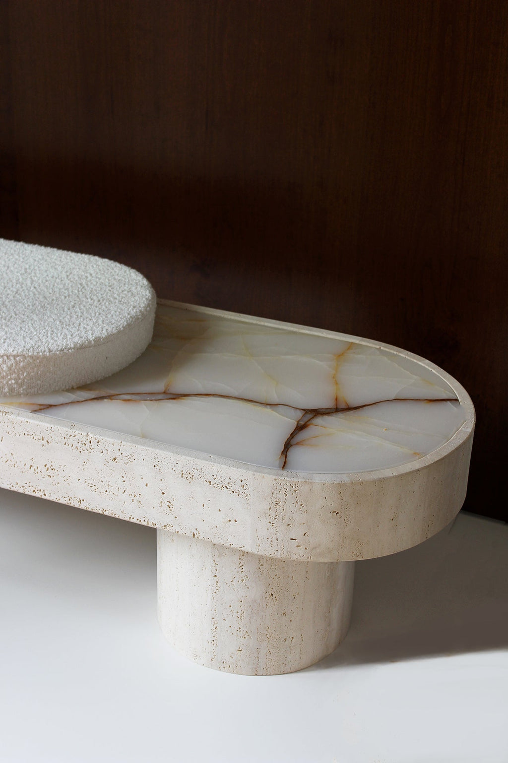 Italian Noto travertine bench with white bouclette upholstery - side perspective showing texture