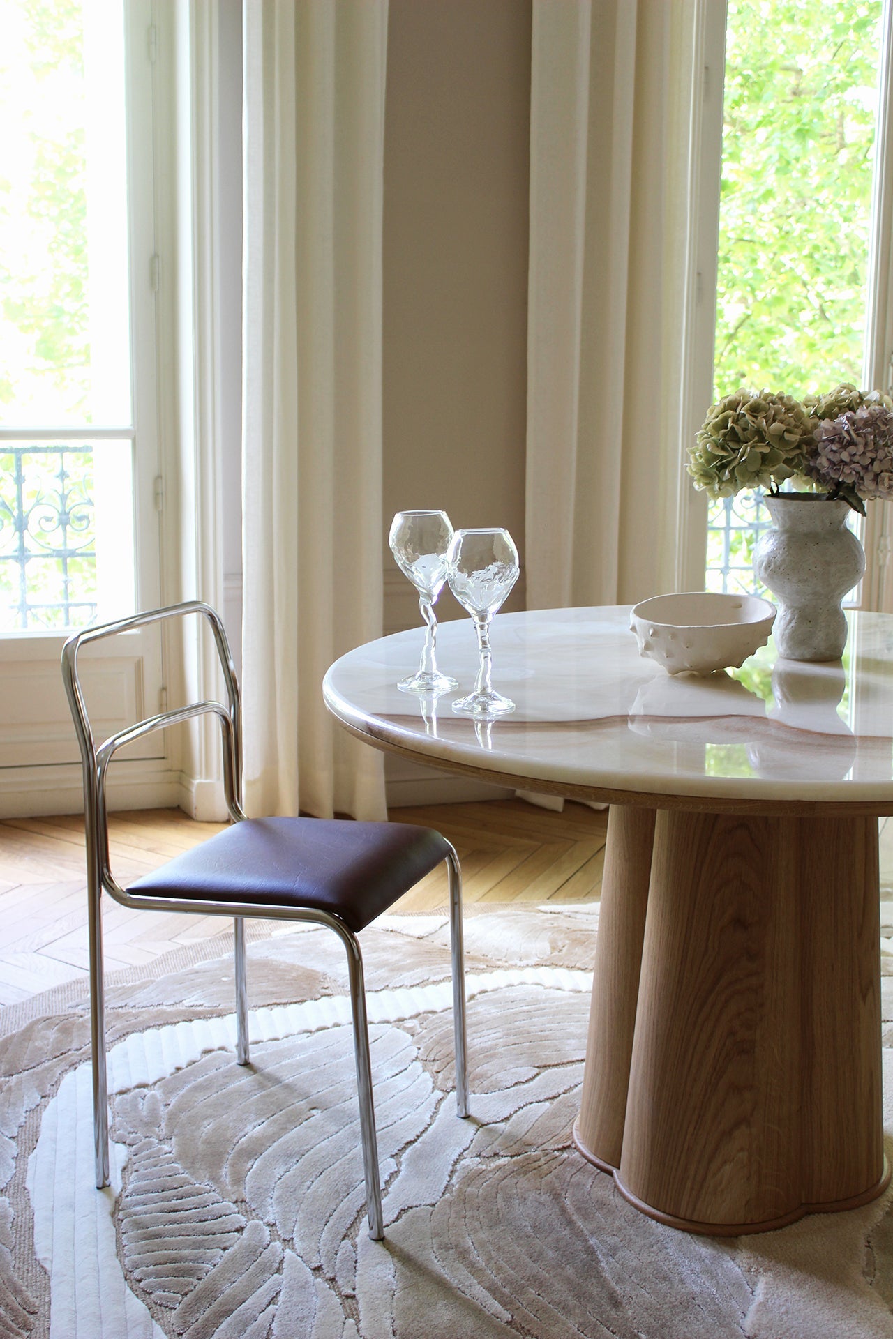 Side profile view of Poli dining table with oak base and vanilla onyx marble surface details