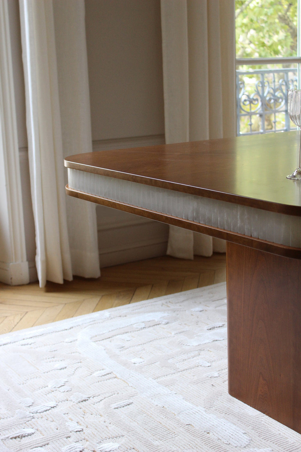 Side view of Doppio wood and white onyx dining table showing sculptural Italian design lines