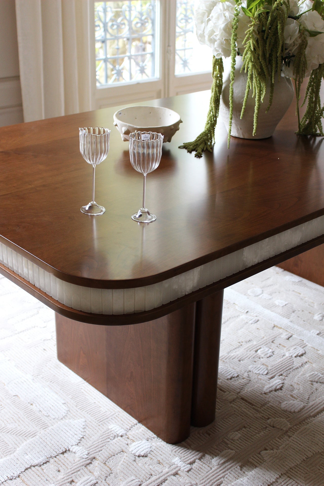 Detailed view of Doppio table's white onyx marble surface with natural wood base - MARBERA quality